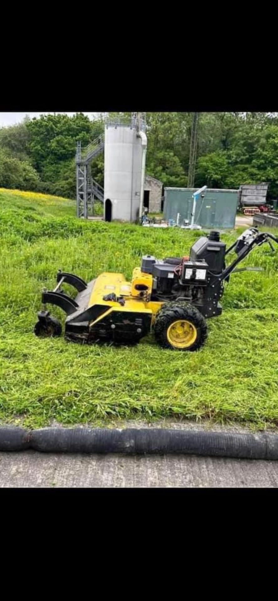 Heavy-duty pedestrian mower on rough ground